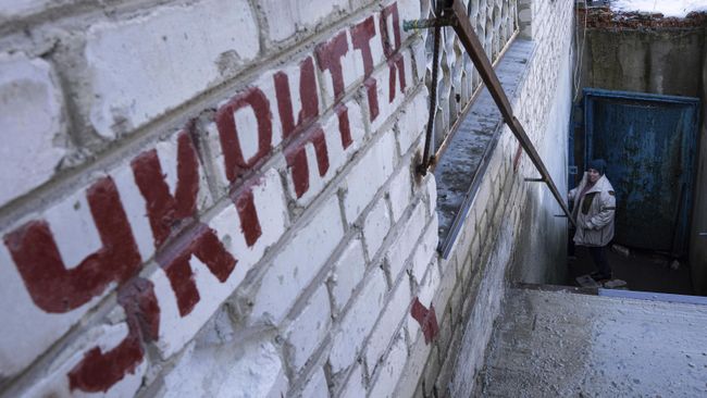 Женщина спускается в бомбоубежище во время воздушной тревоги на Украине 