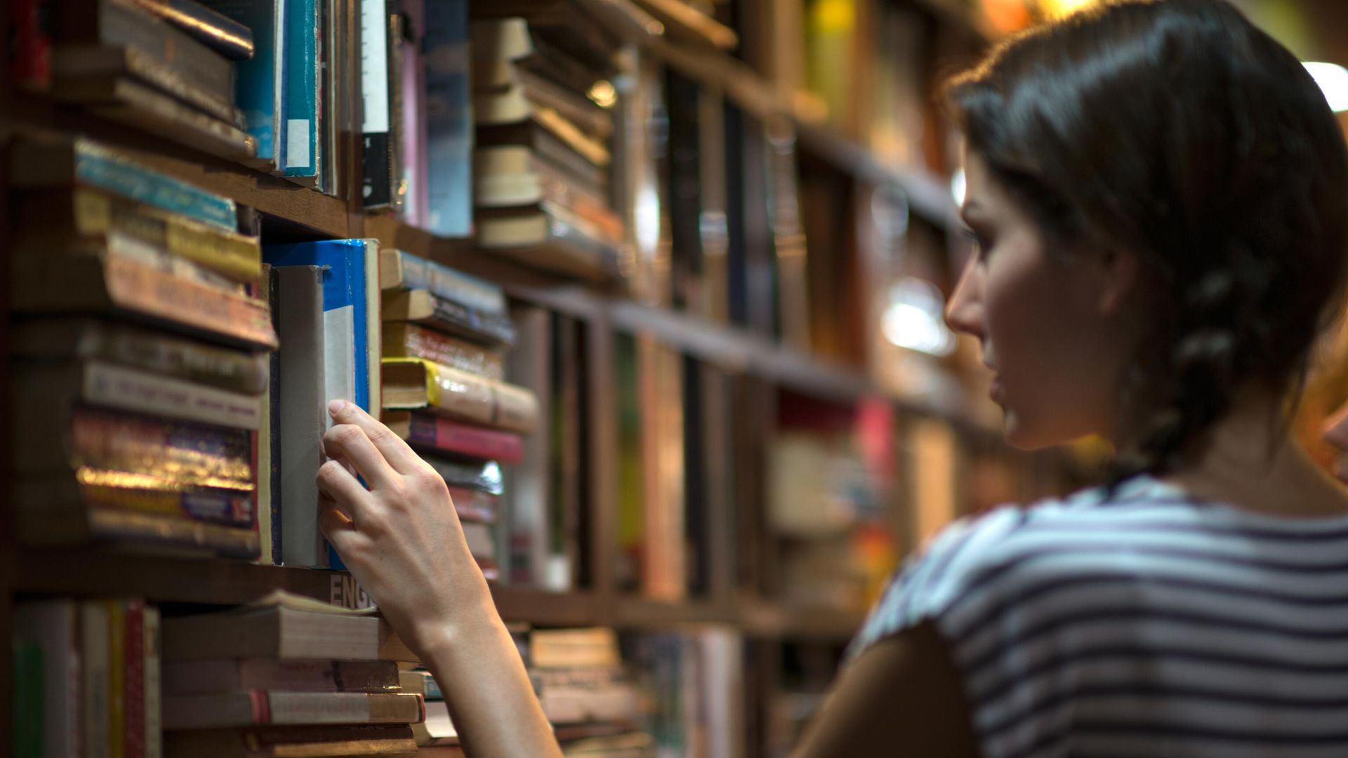 Девушка выбирает книгу в библиотеке Девушка выбирает книгу в библиотеке - РИА Новости, 1920, 17.04.2023