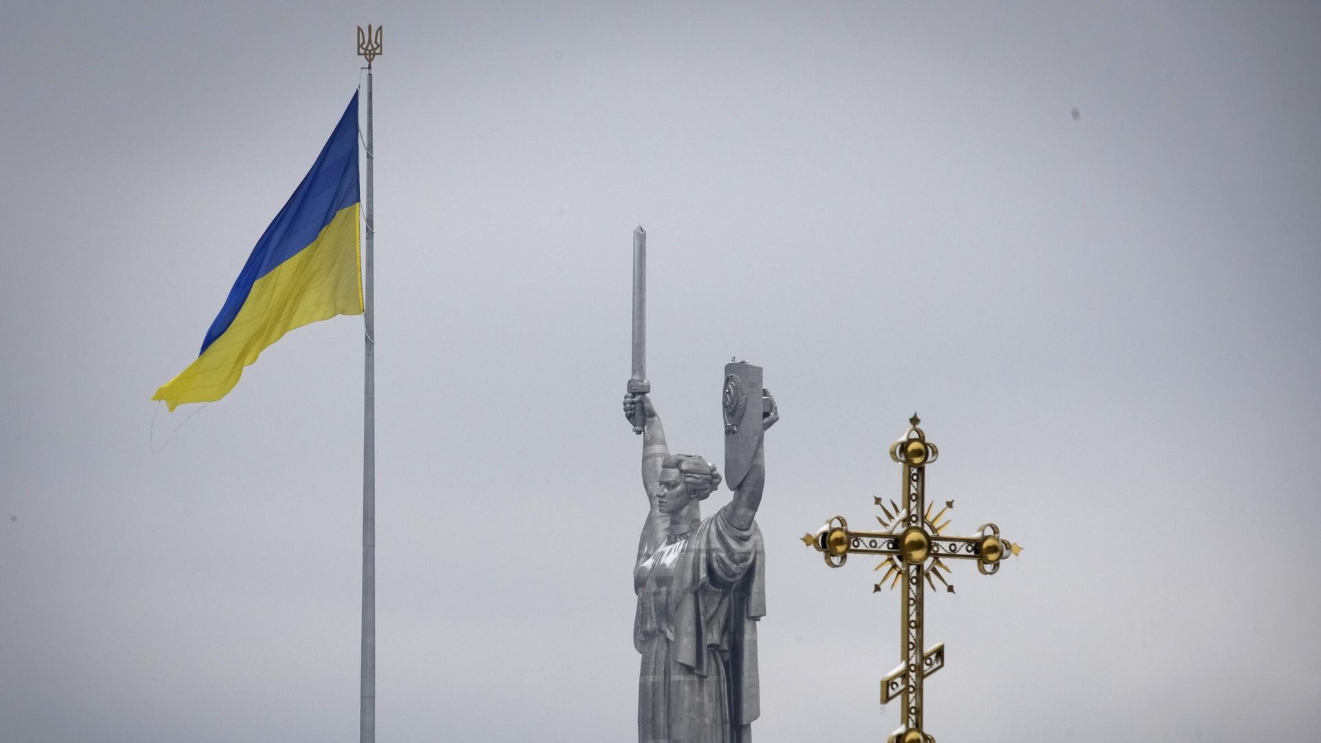 Крест монастырского комплекса Печерской Лавры на фоне украинского государственного флага и монумента Родина-мать в Киеве Крест монастырского комплекса Печерской Лавры на фоне украинского государственного флага и монумента Родина-мать в Киеве - РИА Новости, 1920, 05.03.2023