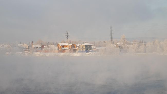 Жилые дома в тумане над рекой Ангара в Иркутске