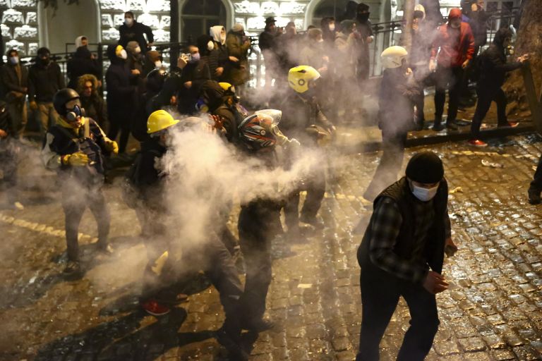 Протестующие бросают дымовую шашку в полицию у здания парламента Грузии в Тбилиси, 8 марта 2023 года Протестующие бросают дымовую шашку в полицию у здания парламента Грузии в Тбилиси, 8 марта 2023 года
