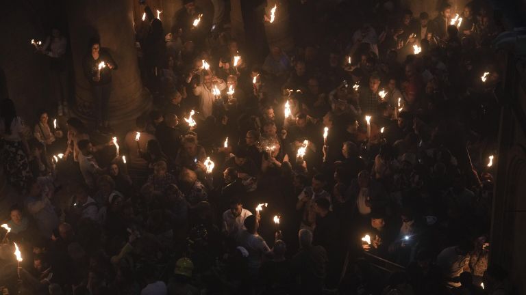 Паломники держат свечи во время церемонии схождения Благодатного огня в храме Гроба Господня Паломники держат свечи во время церемонии схождения Благодатного огня в храме Гроба Господня