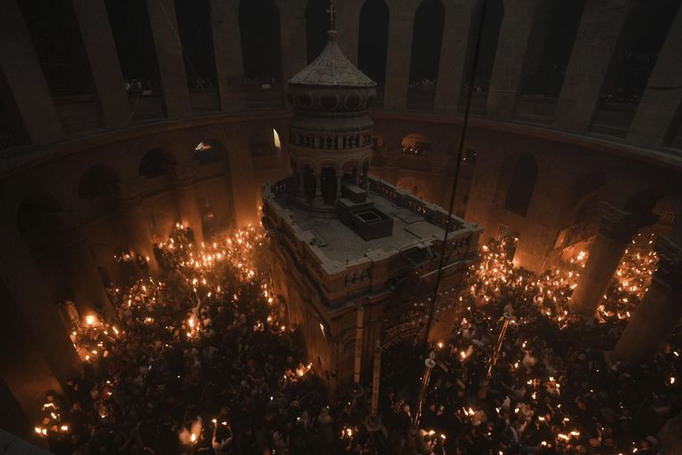 Паломники держат свечи во время церемонии схождения Благодатного огня в храме Гроба Господня Паломники держат свечи во время церемонии схождения Благодатного огня в храме Гроба Господня