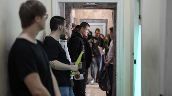 Молодые люди ждут своей очереди для прохождения призывной комиссии в военном комиссариате