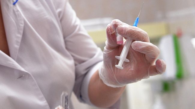 Медицинская сестра готовит шприц для прививки 