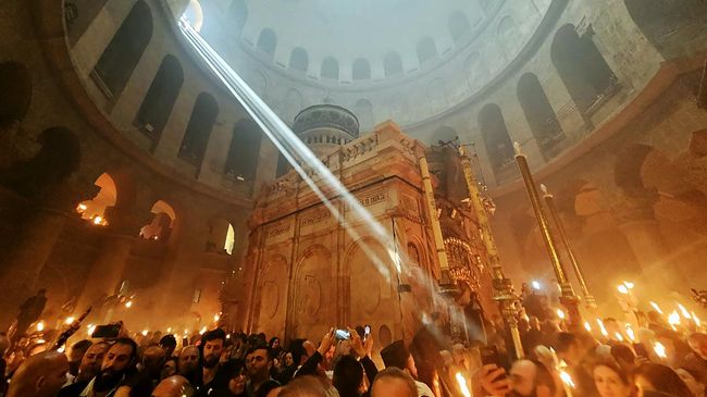 Верующие со свечами и лампадами, зажженными от Благодатного огня, в храме Воскресения Христова (храм Гроба Господня) в Иерусалиме
