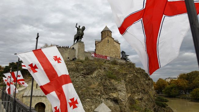 Государственные флаги Грузии украшают мост через реку Кура