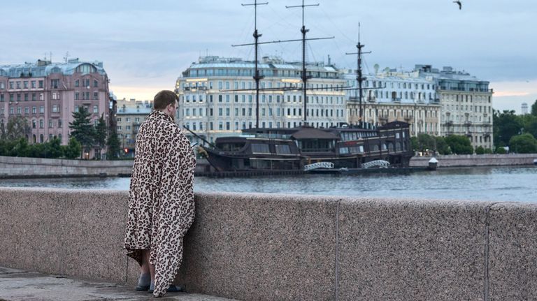 Молодой человек на стрелке Васильевского острова во время белых ночей в Санкт-Петербурге Молодой человек на стрелке Васильевского острова во время белых ночей в Санкт-Петербурге