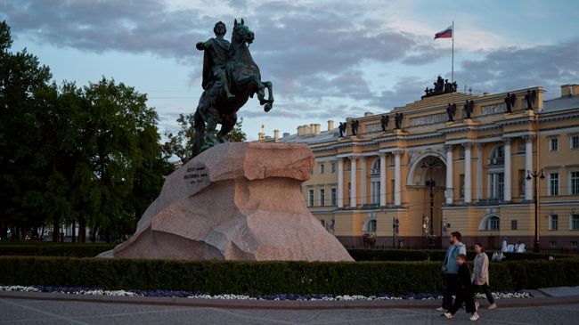 Люди проходят мимо памятника первому российскому императору Петру Великому Медный всадник на Сенатской площади в Санкт-Петербурге