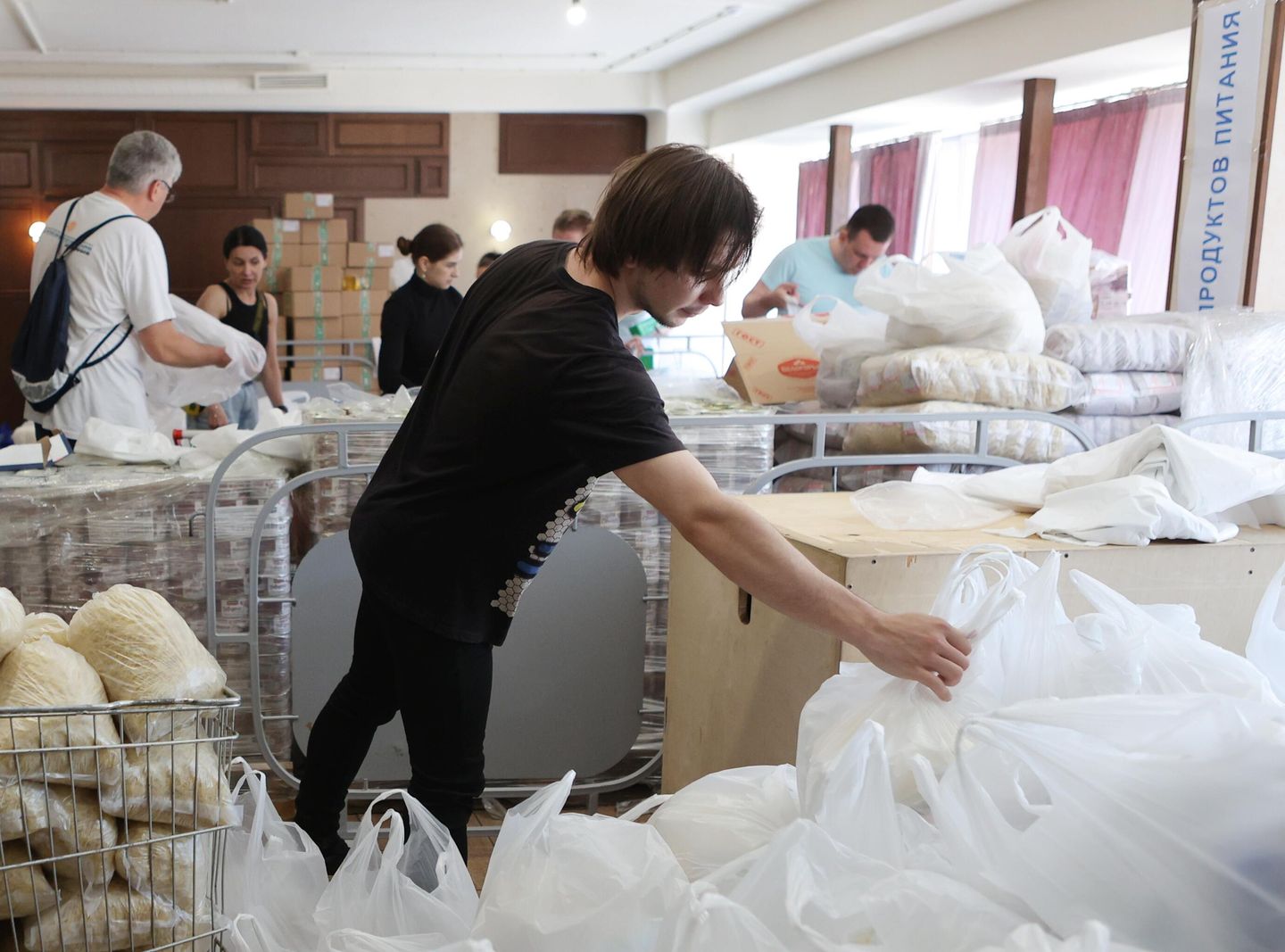 Волонтеры в секторе фасовки продуктовых наборов пункта сбора и выдачи гуманитарной помощи эвакуированным жителям города Шебекино во Дворце спорта Космос в Белгороде Волонтеры в секторе фасовки продуктовых наборов пункта сбора и выдачи гуманитарной помощи эвакуированным жителям города Шебекино во Дворце спорта Космос в Белгороде