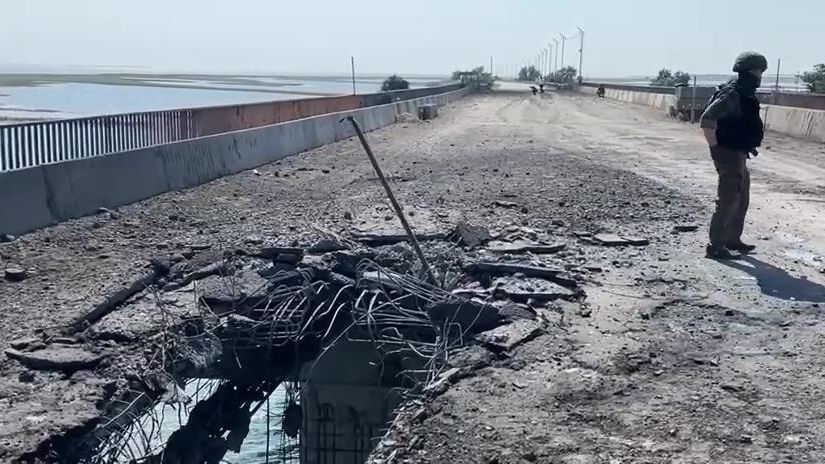 Сотрудник Следственного комитета России на поврежденной дороге на Чонгарском мосту. Кадр видео - РИА Новости, 1920, 23.06.2023