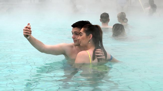 Молодые люди фотографируются в купальне