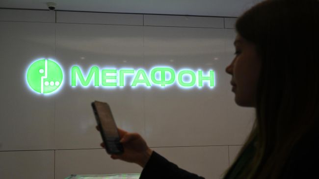 Девушка со смартфоном в офисе компании Мегафон