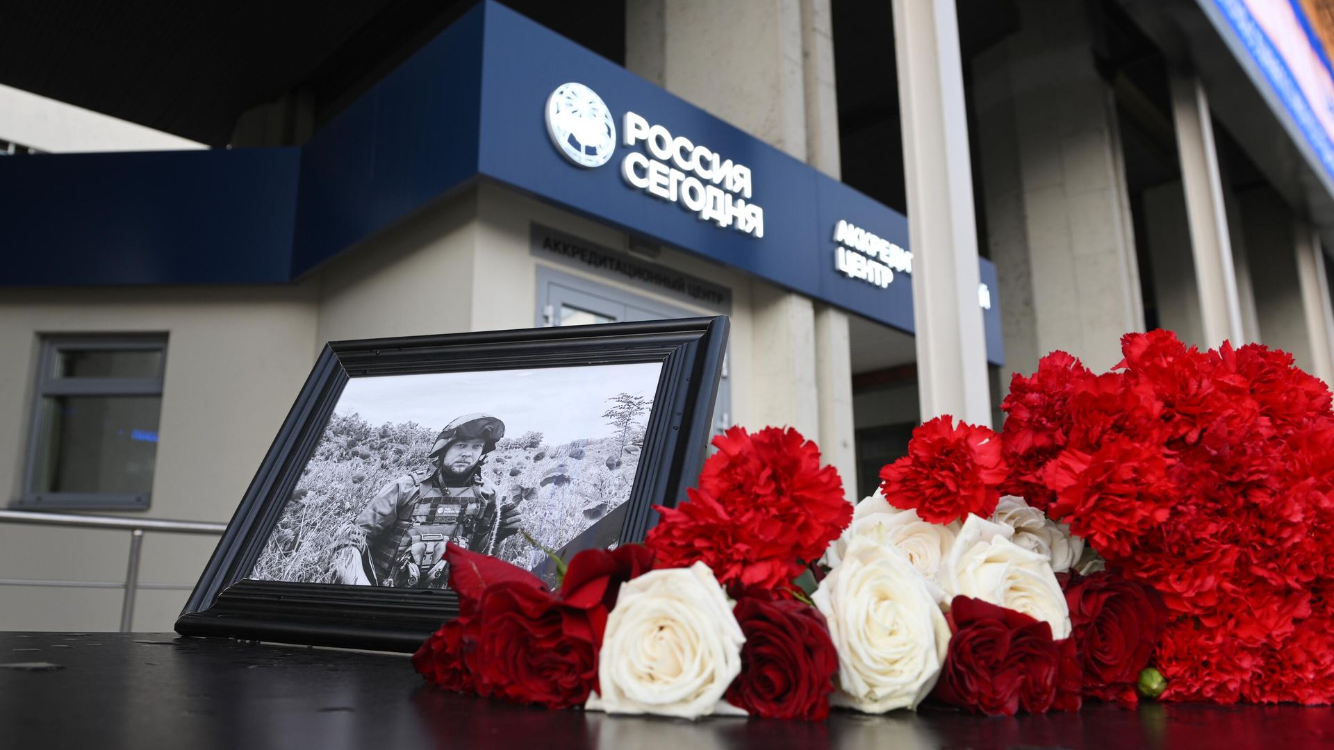 Фотография погибшего военкора РИА Новости Ростислава Журавлева и цветы перед зданием международного информационного агентства Россия сегодня - РИА Новости, 1920, 23.07.2023