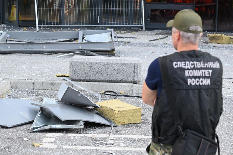 Сотрудник Следственного комитета РФ у поврежденного здания делового центра Москва-сити Сотрудник Следственного комитета РФ у поврежденного здания делового центра Москва-сити