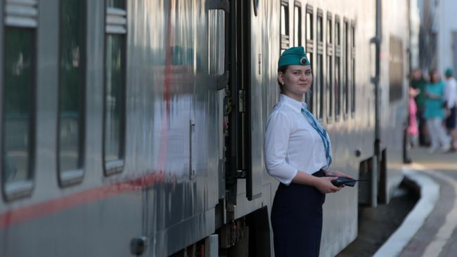Проводник у скорого двухэтажного поезда Таврия из Москвы на железнодорожном вокзале Феодосии
