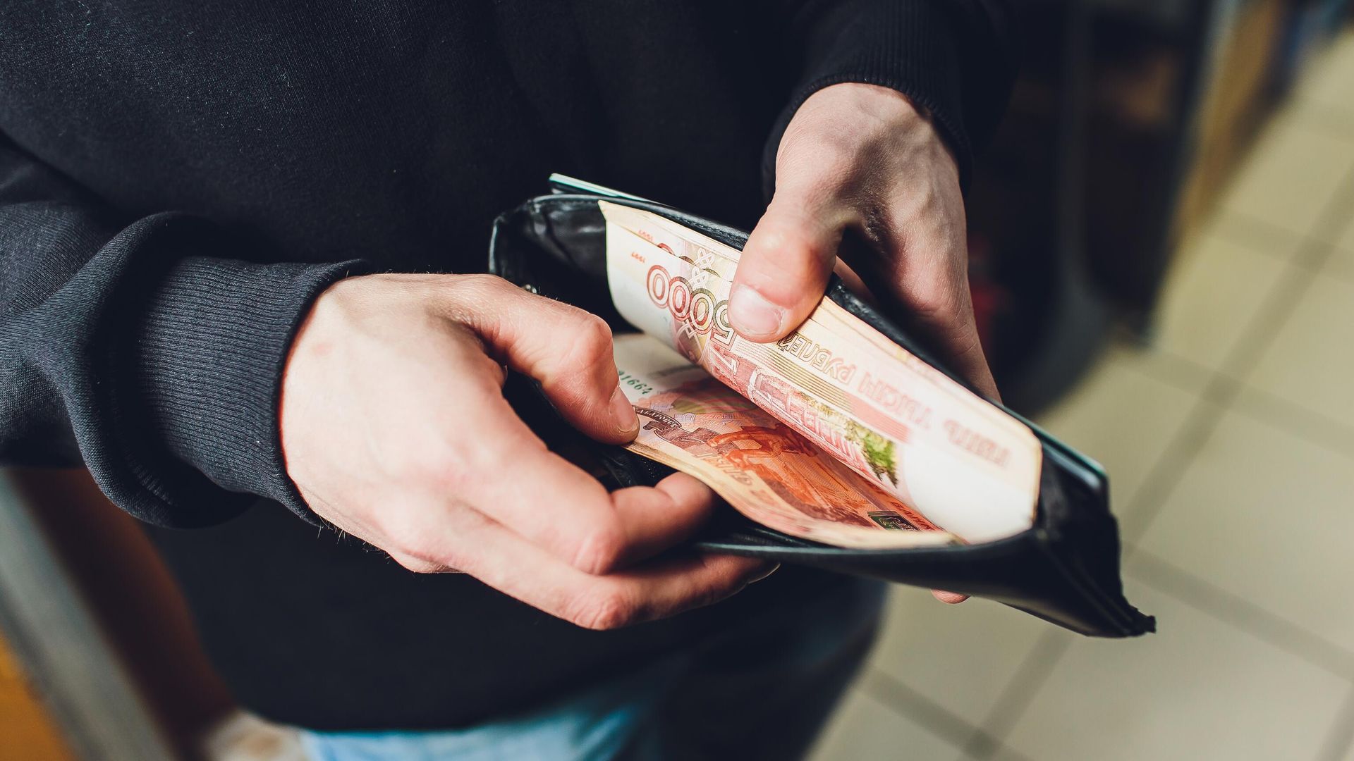 Мужчина достает банкноты из кошелька Мужчина достает банкноты из кошелька - РИА Новости, 1920, 27.11.2023