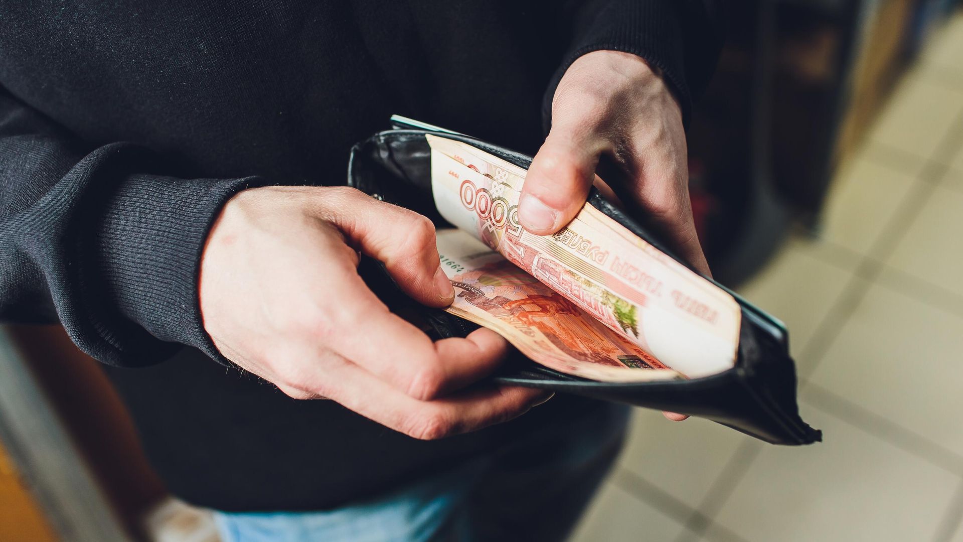Мужчина достает банкноты из кошелька Мужчина достает банкноты из кошелька - РИА Новости, 1920, 27.11.2023