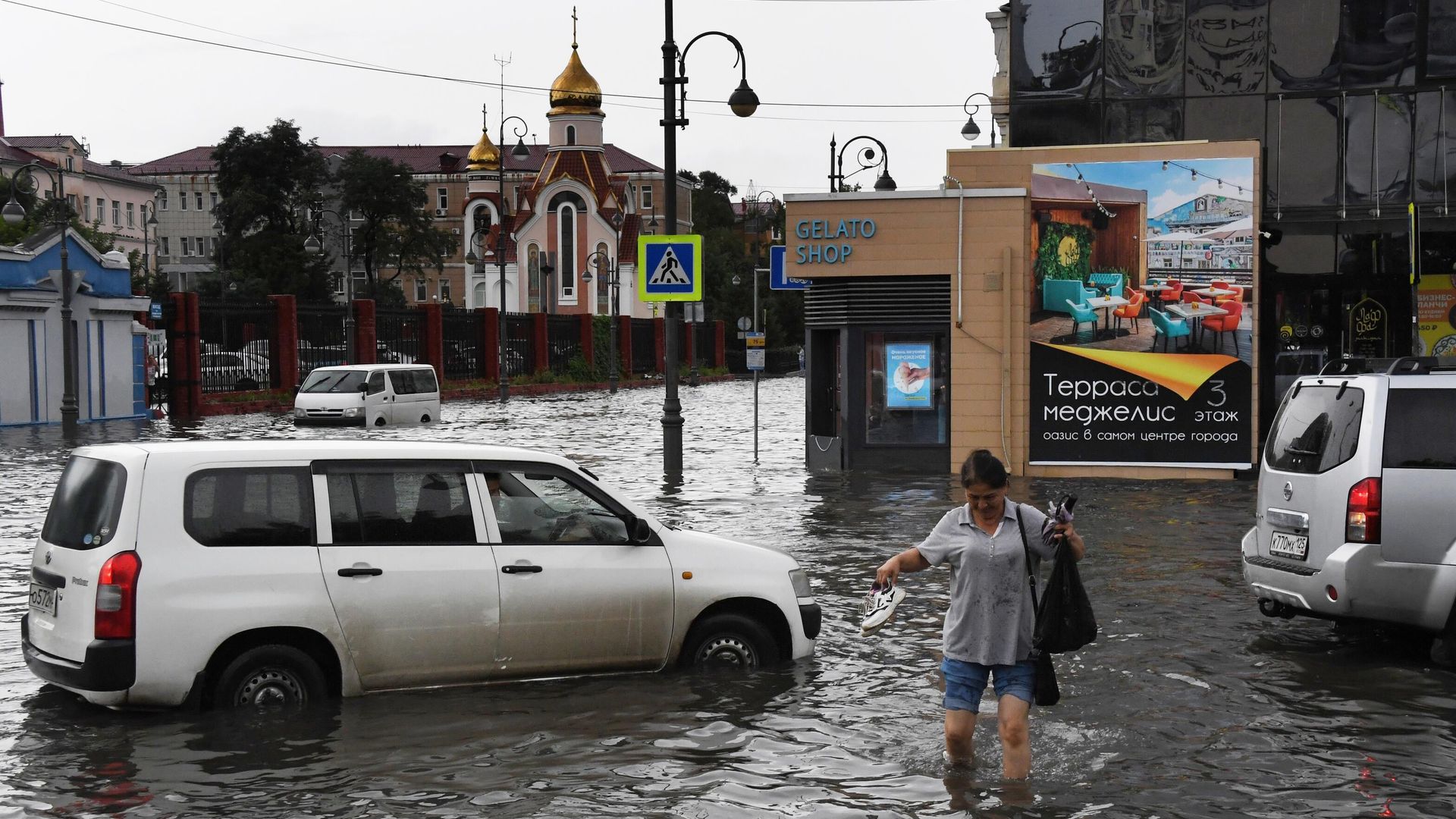 Женщина на одной из улиц Владивостока, затопленных в результате ливня Женщина на одной из улиц Владивостока, затопленных в результате ливня - РИА Новости, 1920, 25.08.2023