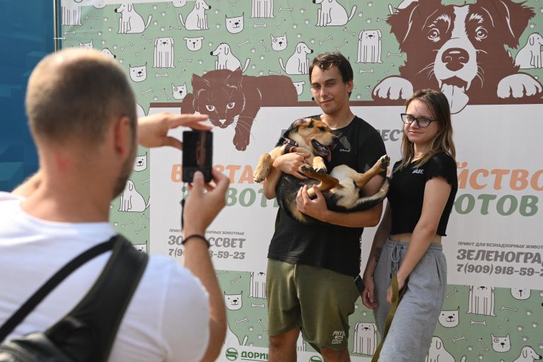 Люди фотографируются с собакой на выставке-пристройстве животных в рамках Московского урбанистического форума - 2023 Люди фотографируются с собакой на выставке-пристройстве животных в рамках Московского урбанистического форума - 2023