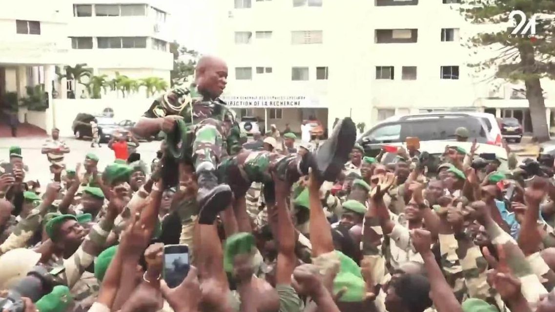 Группа солдат несет на руках генерала Бриса Олиги Нгему. Кадр видео - РИА Новости, 1920, 30.08.2023