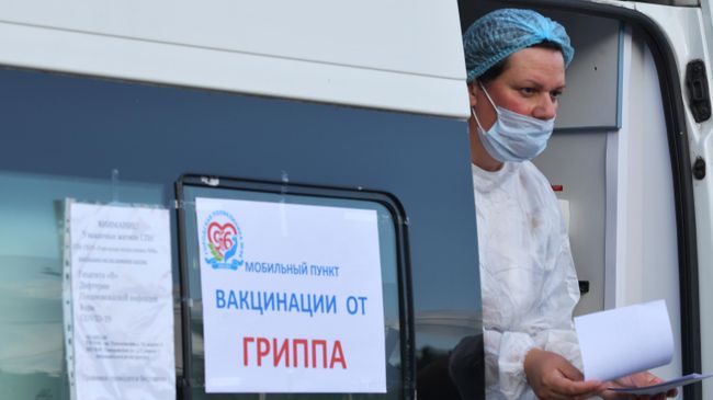 Медицинский работник в мобильном пункте вакцинации населения от гриппа у станции метро Академическая в Санкт-Петербурге Медицинский работник в мобильном пункте вакцинации населения от гриппа у станции метро Академическая в Санкт-Петербурге
