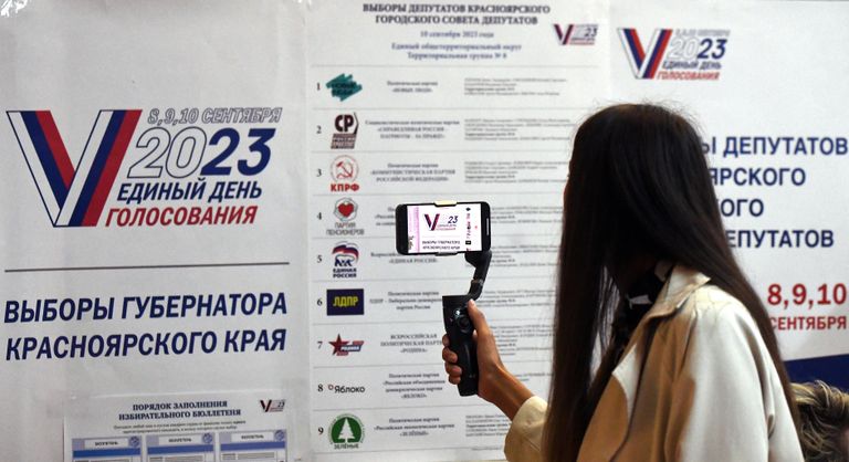 Девушка фотографирует информационный стенд на выборах губернатора Красноярского края и депутатов городского совета депутатов Красноярска на избирательном участке №2320 в микрорайоне Академгородок в Красноярске Девушка фотографирует информационный стенд на выборах губернатора Красноярского края и депутатов городского совета депутатов Красноярска на избирательном участке №2320 в микрорайоне Академгородок в Красноярске