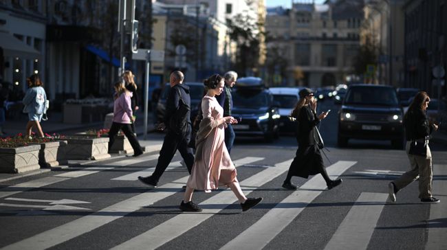 Люди переходят дорогу на Неглинной улице в Москве