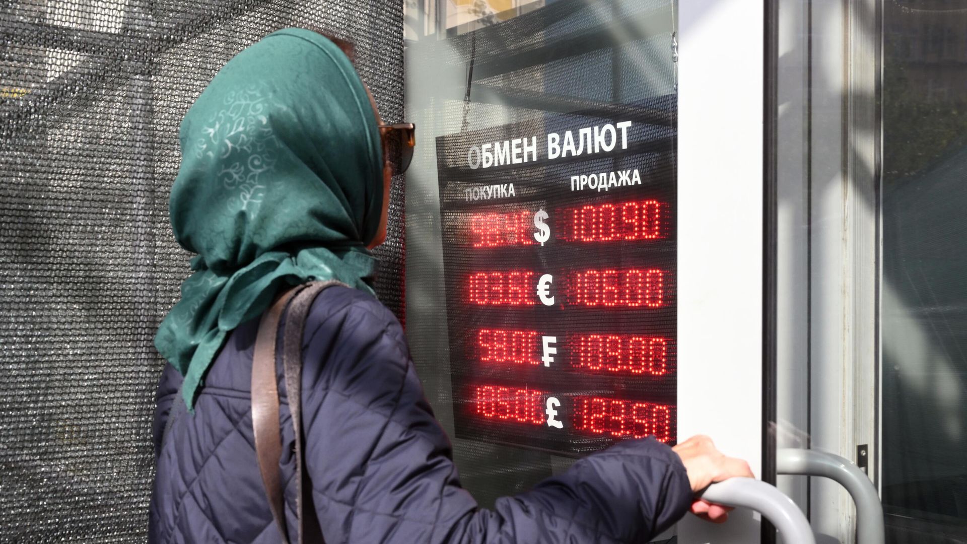 Женщина заходит в пункт обмена валюты в Москве Женщина заходит в пункт обмена валюты в Москве - РИА Новости, 1920, 12.10.2023