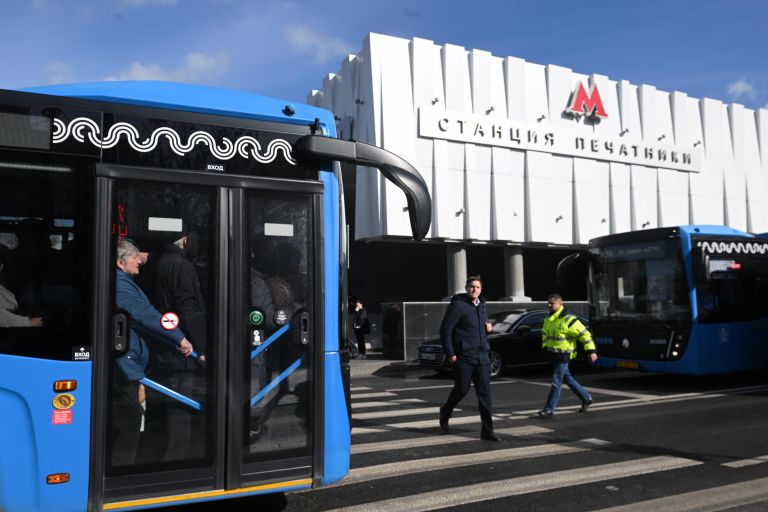Люди в бесплатном автобусе КМ у вестибюля станции метро Печатники в Москве Люди в бесплатном автобусе КМ у вестибюля станции метро Печатники в Москве