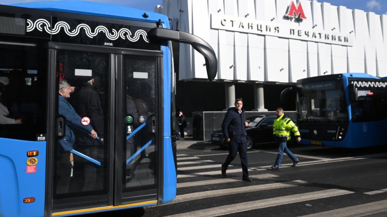 Люди в бесплатном автобусе КМ у вестибюля станции метро Печатники в Москве Люди в бесплатном автобусе КМ у вестибюля станции метро Печатники в Москве