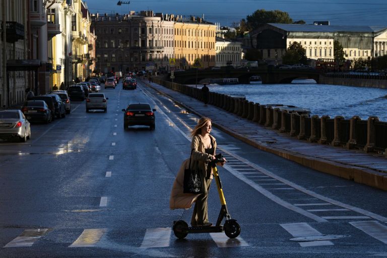 Девушка на самокате на набережной реки Мойка в Санкт-Петербурге Девушка на самокате на набережной реки Мойка в Санкт-Петербурге