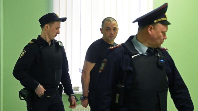 Сотрудники полиции сопровождают Василия Стрижакова в зал заседаний Второго западного окружного военного суда Москвы