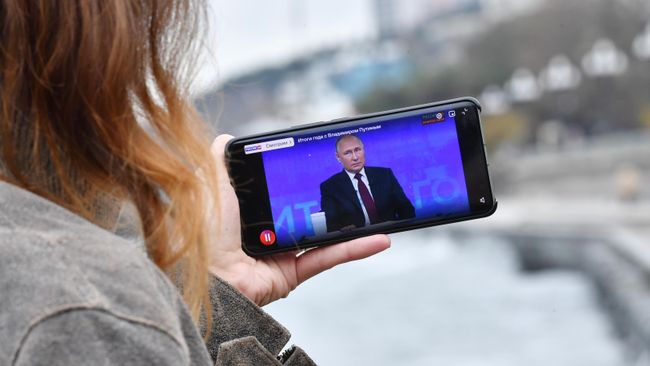 Жительница Симферополя смотрит трансляцию Прямой линии и большой пресс-конференции президента РФ Владимира Путина