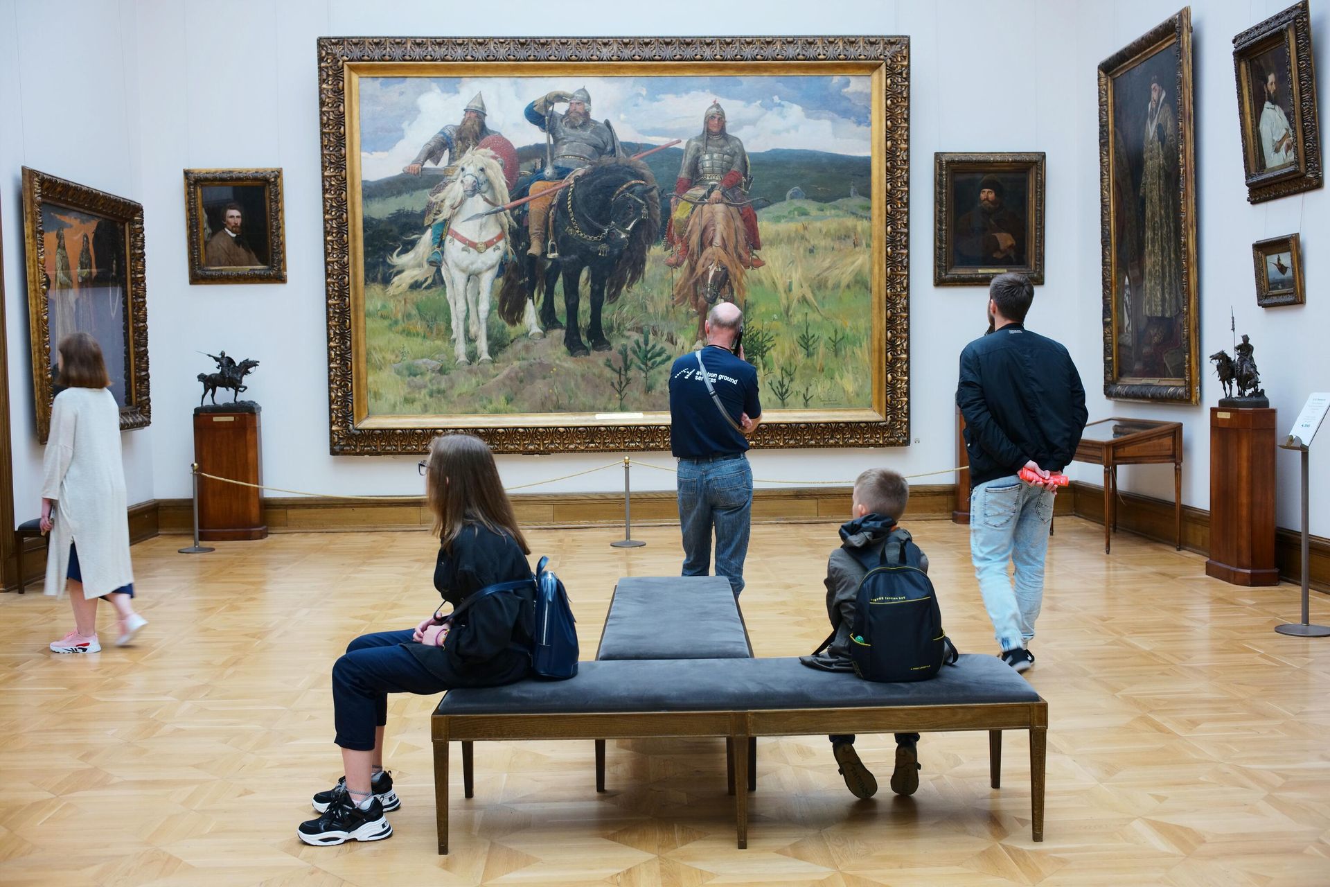 Иностранные туристы у картины Три богатыря художника В. Васнецова в Третьяковской галерее Иностранные туристы у картины Три богатыря художника В. Васнецова в Третьяковской галерее