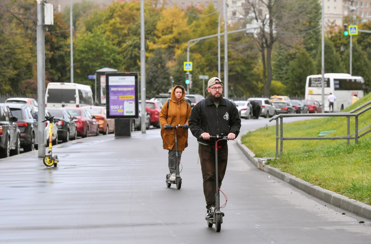 Люди едут на электросамокатах по тротуару на Олимпийском проспекте в Москве Люди едут на электросамокатах по тротуару на Олимпийском проспекте в Москве