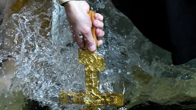 Священнослужитель совершает обряд освящения воды