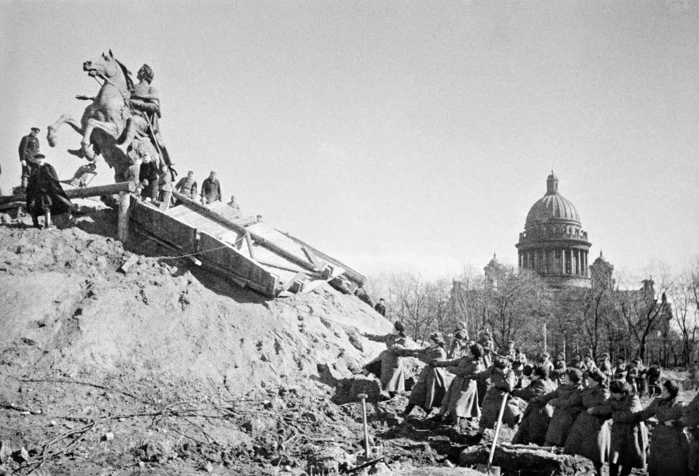 После снятия блокады Ленинграда, жители города освобождают памятник Петру l от защитных укрытий После снятия блокады Ленинграда, жители города освобождают памятник Петру l от защитных укрытий