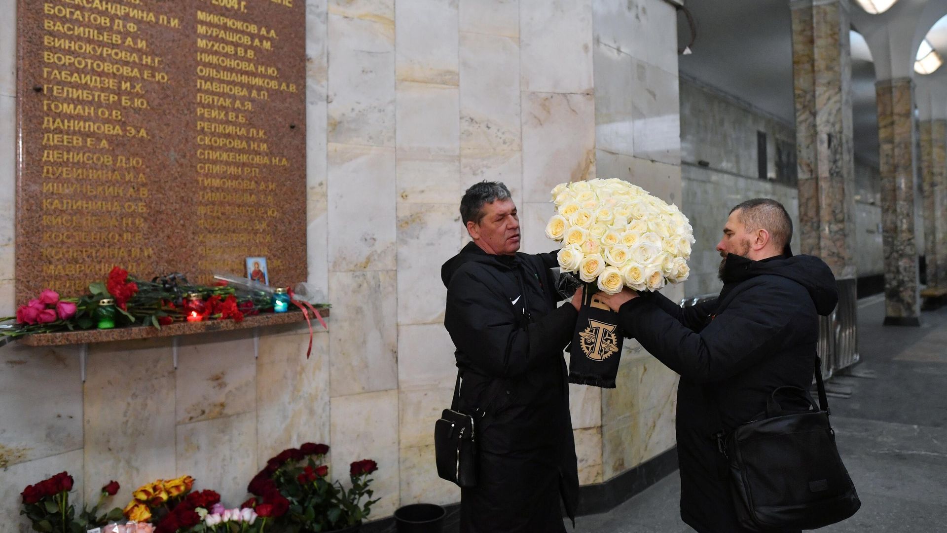 Мужчины оставляют цветы у памятной таблички со списком жертв террористического акта, размещенной на станции метро Автозаводская. 6 февраля 2024 Мужчины оставляют цветы у памятной таблички со списком жертв террористического акта, размещенной на станции метро Автозаводская. 6 февраля 2024 - РИА Новости, 1920, 06.02.2024