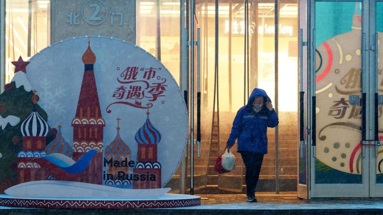 Женщина выходит из торгового центра в городе Шеньян, где проходит ярмарка Сделано в России Женщина выходит из торгового центра в городе Шеньян, где проходит ярмарка Сделано в России