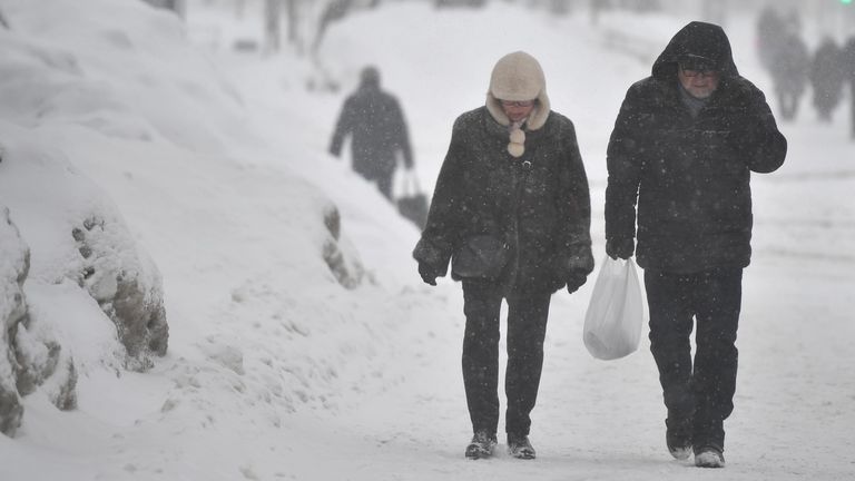 Люди идут по улице в Москве во время снегопада Люди идут по улице в Москве во время снегопада