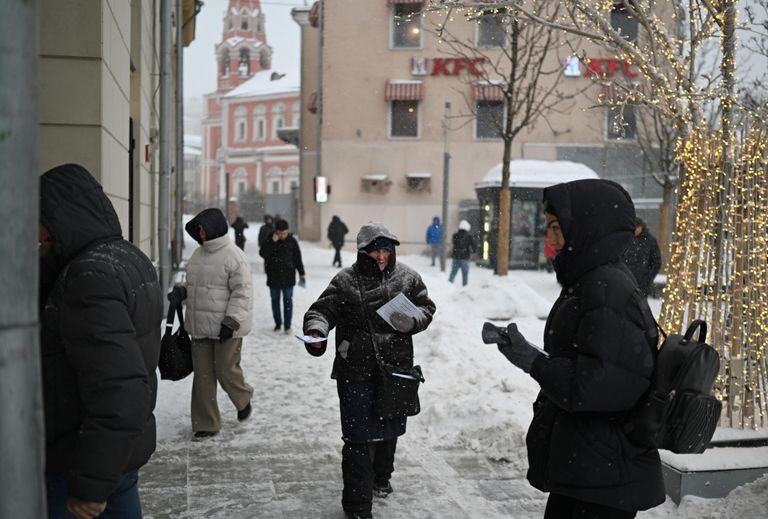 Мужчина раздает листовки во время снегопада в Москве Мужчина раздает листовки во время снегопада в Москве