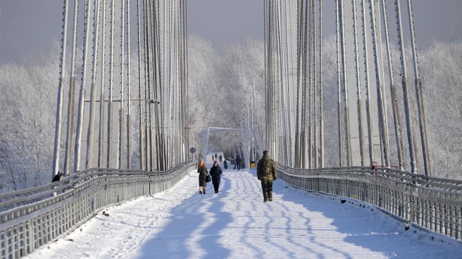Люди гуляют по Виноградовскому пешеходному мосту в Красноярске