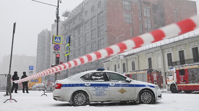 Сотрудники полиции и автомобили спецслужб у здания, где произошел пожар, на Пушкинской площади в Москве Сотрудники полиции и автомобили спецслужб у здания, где произошел пожар, на Пушкинской площади в Москве