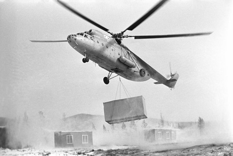Строительство Байкало-Амурской магистрали. Вертолет переносит дома строителей на новое место Строительство Байкало-Амурской магистрали. Вертолет переносит дома строителей на новое место