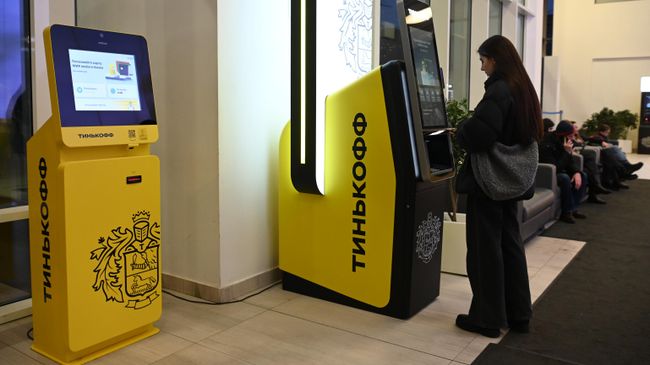 Девушка у банкомата банка Тинькофф в Москве