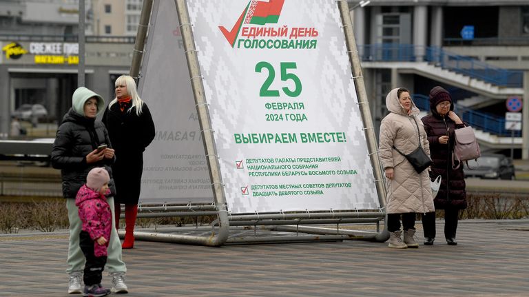 Горожане у агитационного предвыборного баннера в Единый день голосования на улице в Минске Горожане у агитационного предвыборного баннера в Единый день голосования на улице в Минске