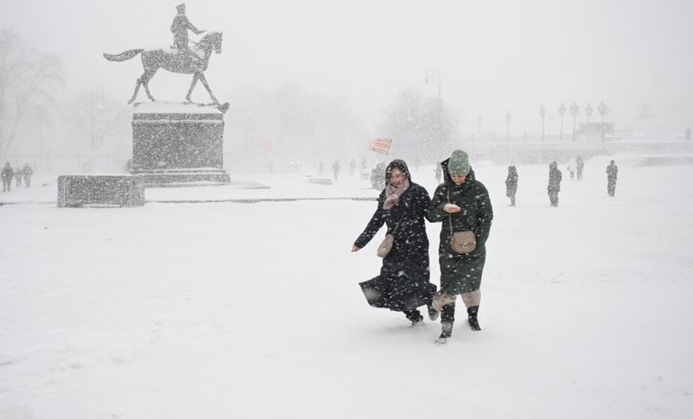 Люди на Манежной площади во время снегопада в Москве Люди на Манежной площади во время снегопада в Москве