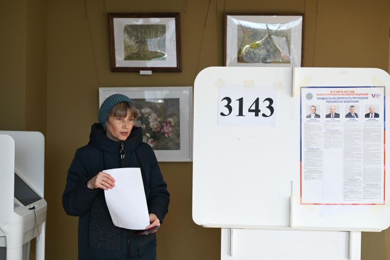 Женщина голосует на выборах президента России на избирательном участке в Москве Женщина голосует на выборах президента России на избирательном участке в Москве