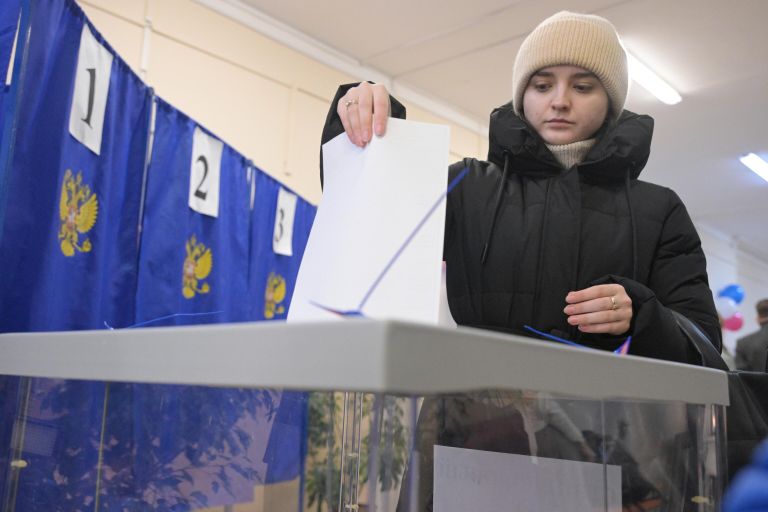 Девушка голосует на выборах президента России на одном из избирательных участков в Новосибирске Девушка голосует на выборах президента России на одном из избирательных участков в Новосибирске